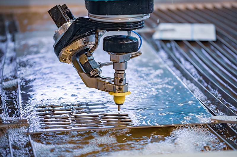 Water jet machine cutting out a part from a piece of material 