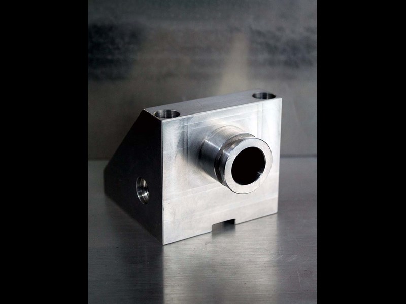 Back view of triangular part with hole in center and a shaft protruding 